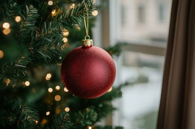 Christmas ornaments hanging on a tree near a window, with natural light enhancing the holiday mood. generated with AI clipart