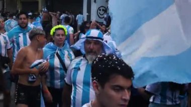 Euphoric taraftarı Arjantin 'deki Dünya Kupası' nı kutlamak için bir sokak lambasının tepesine tırmanır, arka planda ise dikilitaş. Dünya futbol şampiyonası Arjantin şampiyonu. Buenos Aires, Arjantin - 18 Aralık 2022
