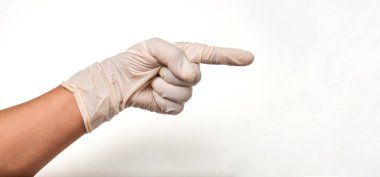 Beyaz bir arkaplanı işaret eden eldivenli Latin doktor..