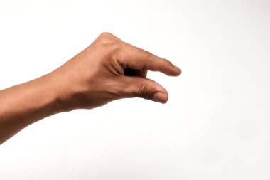 Beyaz arka planda küçük bir şey tutan Latin bir adamın eli. El hareketi bir çimdik ya da bir tutuş olduğunu gösterir. Küçük, iletişim ve etkileşim için ideal. Yakın çekim görünümü.