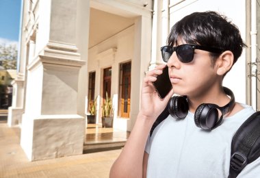 Genç adam akıllı telefon açık havada üzerinde konuşuyor 