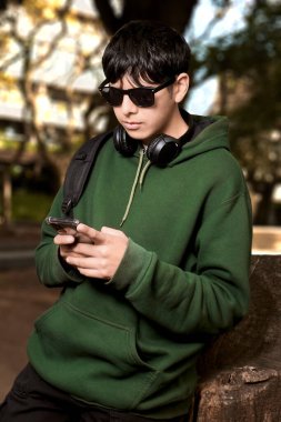 Parkta Otururken Akıllı Telefon Kullanan Genç 