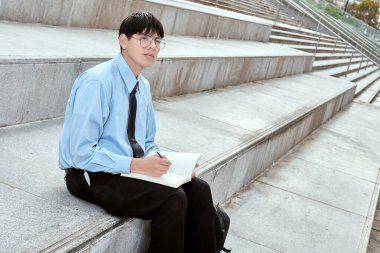 Açık havada Not Defterine Odaklanmış Genç Profesyonel Yazma