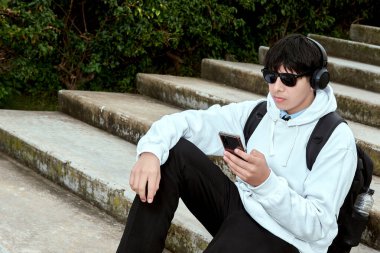 Gençler Kulaklıkla Müzik Dinlerken Dışarıdaki Taş Merdivenlerde Otururken