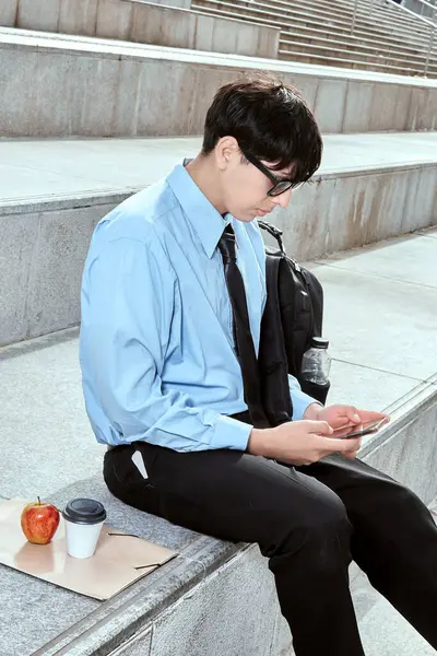 Genç ofis çalışanı kahve molası sırasında mesajlaşıyor.