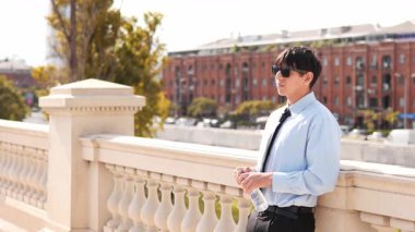  Güneş gözlüklü genç adam güneşli bir günde su içiyor.