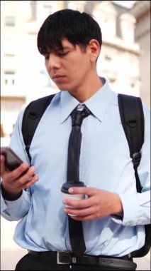  Adam şehirde kahve içerken telefonla konuşuyor.