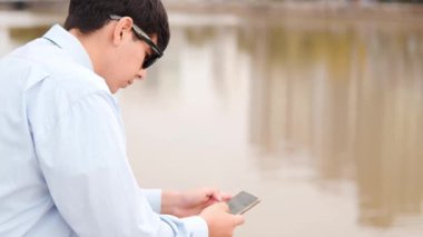  Genç Adam Nehrin Yanındaki Akıllı Telefona Odaklandı