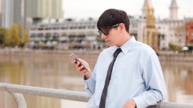  Waterfront 'tan Resmi Gömlekli Genç Adam Smartphone