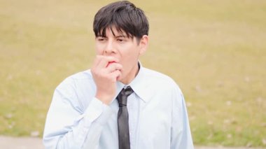  Ofis çalışanı molada dışarıda elma yiyor.