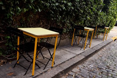 Sarı Masalar ve Siyah Sandalyeler Buenos Aires 'teki kaldırımlı kaldırım kahvesi.