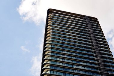 Mavi Gökyüzüne Karşı Kıvrımlı Balkonları olan Modern Yüksek Katlı Kule