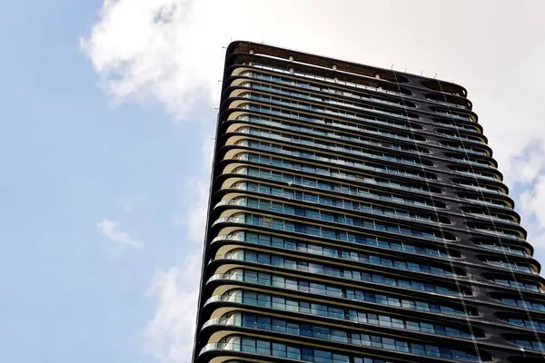 Mavi Gökyüzüne Karşı Kıvrımlı Balkonları olan Modern Yüksek Katlı Kule