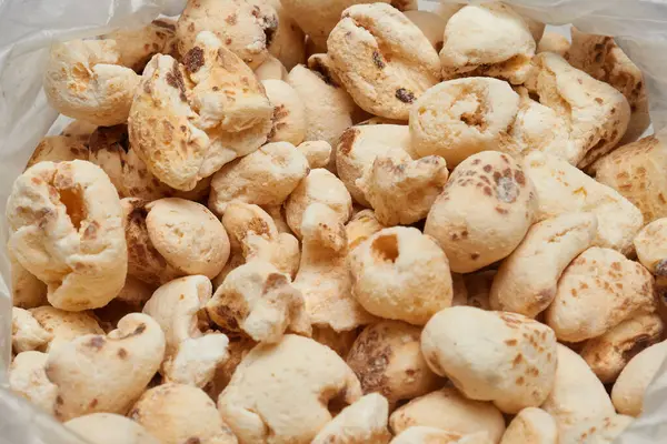  Beyaz arka planda izole edilmiş, gevrek desen tatlılığını ve el yapımı basitliği vurgulayan açık bir poşetin içindeki patlamış mısır atıştırmalığını kapat..