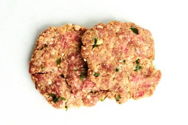 Pişmemiş hamburgerler ev yapımı hazırlanmayı ve protein zengini öğünlerin ızgara yapma ve konfor pişirme konseptini öneriyor. beyaz arkaplanda izole
