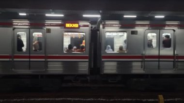 Jakarta, Endonezya. 27 Eylül 2024. Kampung Bandan İstasyonu 'ndan yavaş yavaş ayrılan banliyö hattı Jakarta ve birkaç kişi diğer banliyö hattını beklerken görüldü..