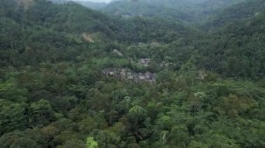 İnsansız hava aracı görüntüsü Baduy Kabilesi 'nin geleneksel evleri yeşil ormanın ve akan nehrin ortasında düzgünce düzenlenmiştir. Bu yerleşim yeri Kanekes Köyü 'nde, Banten Eyaleti, Endonezya' nın Lebak Regency bölgesinde yer almaktadır..