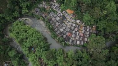 İnsansız hava aracı görüntüsü Baduy Kabilesi 'nin geleneksel evleri yeşil ormanın ve akan nehrin ortasında düzgünce düzenlenmiştir. Bu yerleşim yeri Kanekes Köyü 'nde, Banten Eyaleti, Endonezya' nın Lebak Regency bölgesinde yer almaktadır..