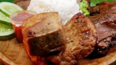 Nasi Kampüsü geleneksel bir Endonezya yemeğidir. Beyaz pirinç, ızgara tavuk, tofu, tempeh, acı sos ve taze salatalıktan oluşur..