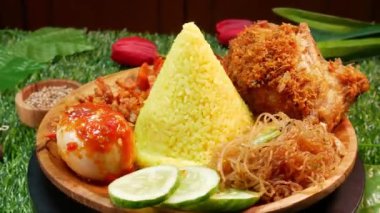 Endonezya spesiyali koni şeklinde sarı pirinç, kızarmış tavuk, sambal yumurta, salatalık dilimleri ve taze kırmızı sambal..