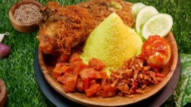 Top View Endonezya spesiyali koni şeklinde sarı pirinç, kızarmış tavuk, kızarmış vermicelli, sambal yumurtası, salatalık dilimleri ve taze kırmızı sambal..