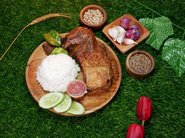 Nasi Campur is a traditional Indonesian food, consisting of white rice, grilled chicken, tofu, tempeh, chili sauce, and fresh cucumber, on a wooden plate on a synthetic grass base. clipart