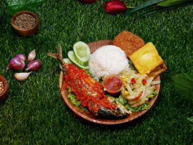 Beyaz pirinç, kırmızı sambal, kızarmış tempeh, kızarmış tofu, taze sebze, sambal ve salatalık dilimleri içeren tam bir yemek..