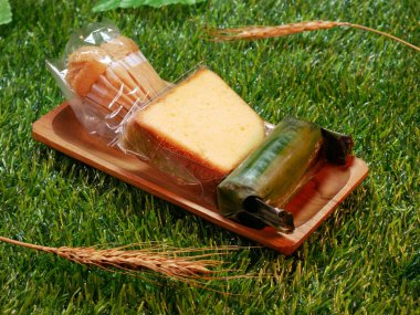 Endonezya geleneksel pastası Bolu Kukus 'u ya da buğulanmış sünger keki, tatlı ve lezzetli Kue Bolu ve Lemper' ı Doğal Dekoratif Dokunuşlar Sentetik ve Buğday saplarıyla kapat