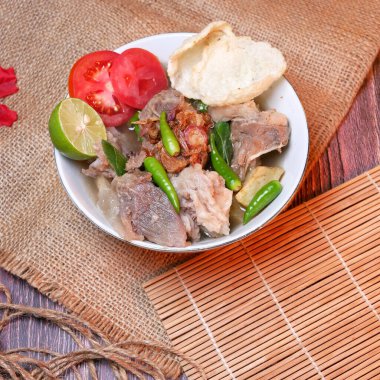 Sığır pirzolası çorbası ya da et, patates, taze domates, limon, yeşil biber, kızarmış soğan ve kraker karışımı Iga çorbası. Benzersiz bir dekorasyonla beyaz bir kasede servis edilmiş. Kullanılabilir metin için boşluk