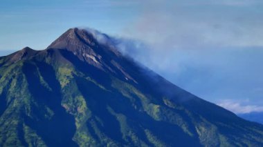 Merapi Dağı 'nın görkemli zirvesi uzak mesafeden aktif olarak volkanik duman yayıyor. Fotoğraf Merbabu Dağı Yürüyüş Yolu 'ndan çekildi..