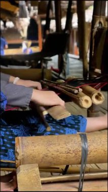 Çevik el hareketleri olan bir kız bambudan yapılmış geleneksel bir dokuma tezgahı kullanıyor. Dokuma becerileri Baduy kabilesindeki her kadın için gelenek ve gelenekleri korumak zorunludur..