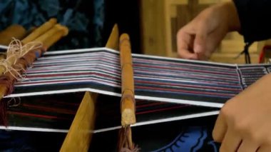 Çevik el hareketleri olan küçük bir kız örgü örmeyi öğreniyor. Dokumacı olmak Baduy Kabilesi 'ndeki her kadının kültürel mirası ve gelenekleri sürdürmesi için bir zorunluluktur..