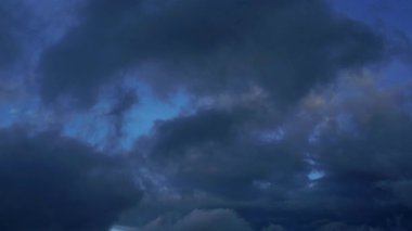 Hava kararmadan önce dramatik gökyüzünde uçan drone dolunayın güzelliğini gösteriyor. Karanlık bulutlar arasında hafif bir ışık yayıyor. Yağmur yağmadan önce rüzgarda hareket ediyor.