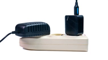 Kırmızı gösterge ışığı, büyük adaptör ve siyah USB şarj aleti olan eklenti soketi beyaz arka planda izole edilmiş. Günlük elektrik kullanımını göstermek için mükemmel..