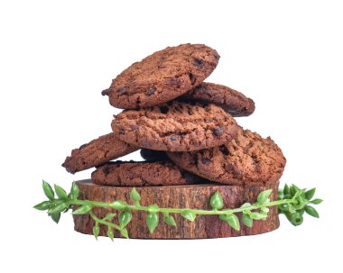 Plastik yaprakla süslenmiş ahşap tabana yerleştirilmiş çıtır çikolatalı kurabiyeler. Yemek reklamı için uygun. Beyaz Arkaplanda İzole Edilmiş