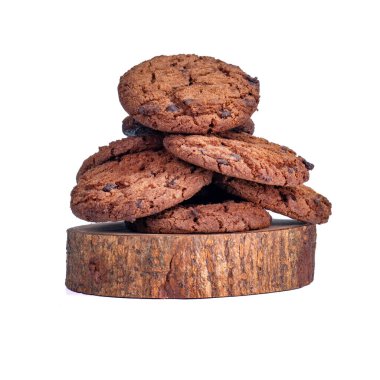 Yuvarlak ahşap bir zemine yerleştirilmiş gevrek çikolata parçacıklı kurabiyeler, beyaz bir arka plan, yemek içeriği veya reklam için mükemmel..