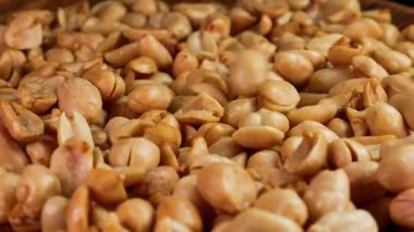 Yavaşça soyulan tuzlanmış fıstıkların dönen ahşap bir tabağa düşmesi. Reklam ya da tanıtım için uygun.