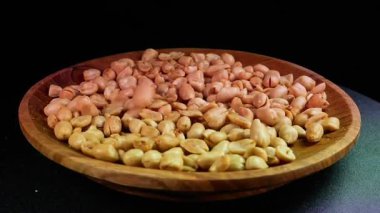 Kavrulmuş tuzlu fıstık dönen ahşap tabağa düşer. Reklam ya da tanıtım için uygun.