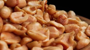 Koyu bir arka planda ahşap bir tabakta kabuklu kavrulmuş fıstık yakın plan. Reklam ya da tanıtım için uygun. Yatay çekim