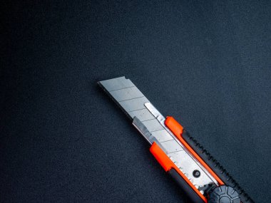 Profesyonel araç sunumları için koyu dokulu arka plan üzerine yerleştirilmiş, ergonomik tasarım ile keskin bir kullanım kesici yakın çekim.