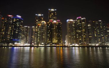 Tourist attraction, Busan Haeundae Marine City, a maritime city in Korea. The high-rise buildings with lights on are even more beautiful when reflected in the sea. clipart