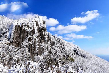 Seoseokdae and Ipseokdae, columnar joints in Gwangju Mudeungsan National Park, a UNESCO World Heritage Site. Covered in white snow, their mystique is at its peak. clipart