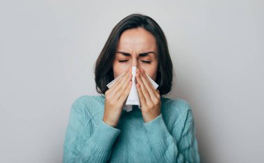 Yüksek ateşi olan genç bir kadın öksürüyor. Grip ve baş ağrısı olan hasta bir kadın. Rhinitis, soğuk, hastalık, alerji konsepti. Öksürük nöbeti. Coronavirüs salgını
