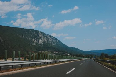 Ormanlarla kaplı dağlardaki güzel manzaralar. Modern ve yüksek kalitede bir otoyolda araba penceresinden görüntü.