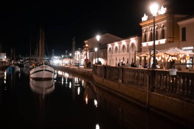 Venedik, İtalya - 11 Haziran 2022: Tekneler deniz kanalındaki rıhtımlara demirlediler. Yerel halk ve turistler tatillerde yürüyüşe çıkacaklar..