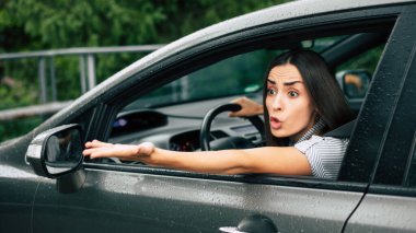 Trafik sıkışık. Saldırgan sürücü. Araba kazası. Kapalı portre, kızgın bir kadının araba kullanmasından ve yumruğu havada birine bağırmasından rahatsız oluyor. Negatif insan ifadesi