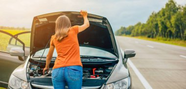 Bozuk ya da yolda bozuk bir araba. Problemli araba kullanırken genç kadın sürücünün arka plan fotoğrafı. Araç Sigortası, Bakım ve Servis Konsepti