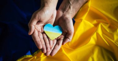 Ukrayna bayrağının renginde kalp bayrak arka planında. Ukrayna 'daki savaşı sona erdirmek. Yardım ve destek. Güçlü bir ülke. Adalet, özgürlük ve demokrasi için savaş.