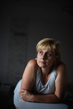 Kendine güveni tam, olgun bir kadının resmi. Günlük kıyafetleri içinde.