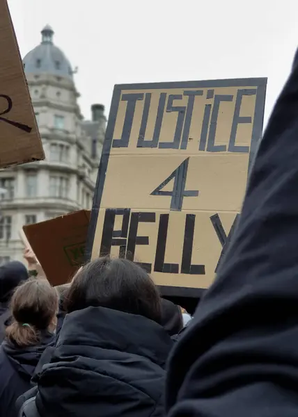 İnsanlar Londra 'da bir BLM protestosunda ırkçılığa karşı yürüyorlar, ellerinde adalet ve eşitlik işaretleri var.
